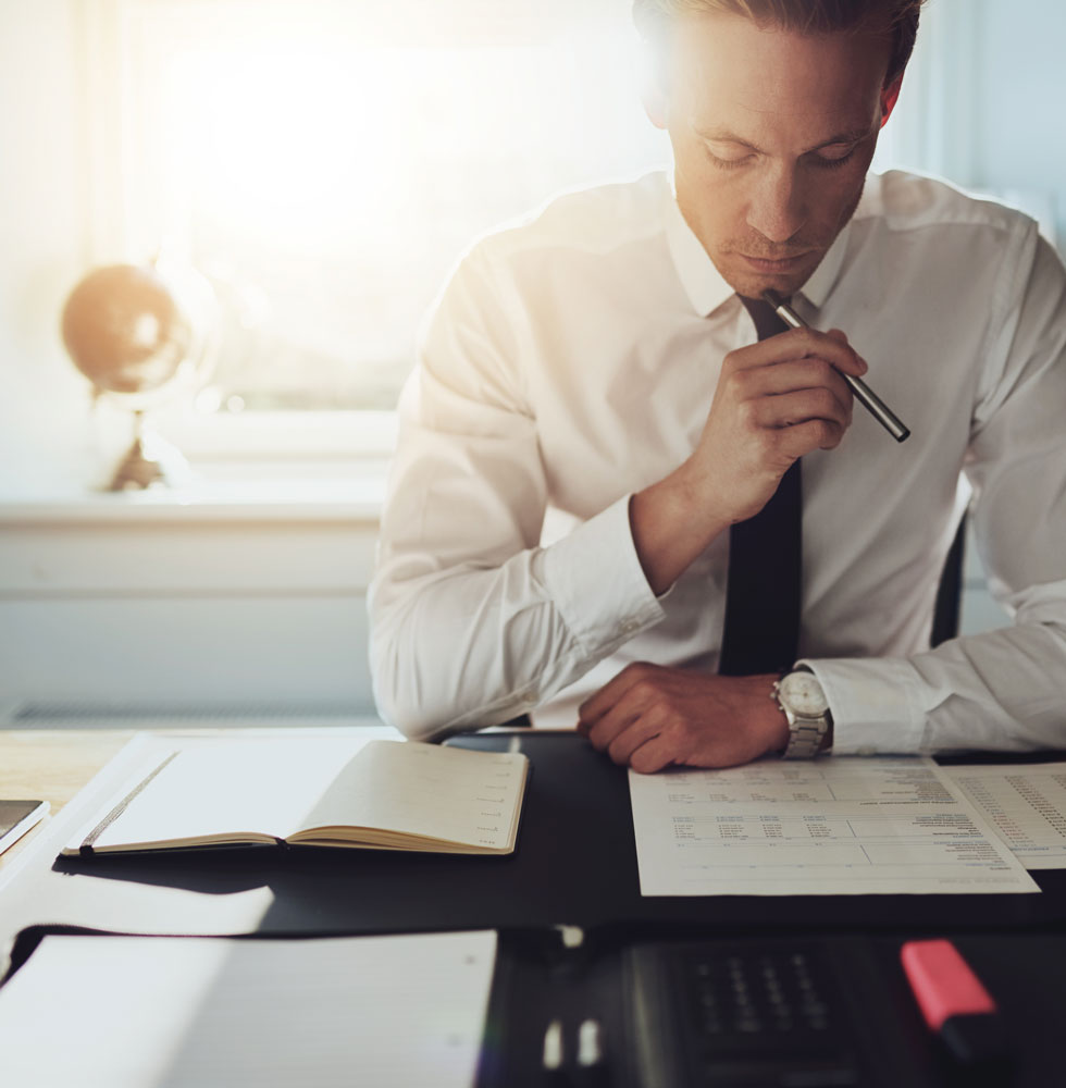 photographie d'un homme d'affaires en train d'analyser un contrat